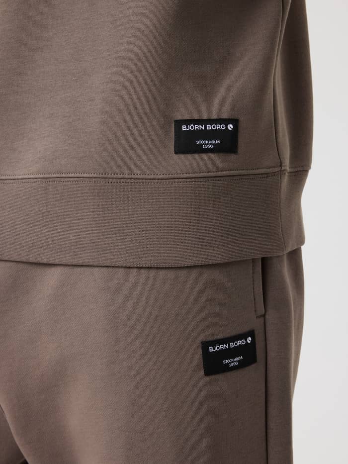 Gros plan sur les étiquettes logo noires Björn Borg du Centre Half Zip Falcon (Marron) et du pantalon assorti. - Image 4