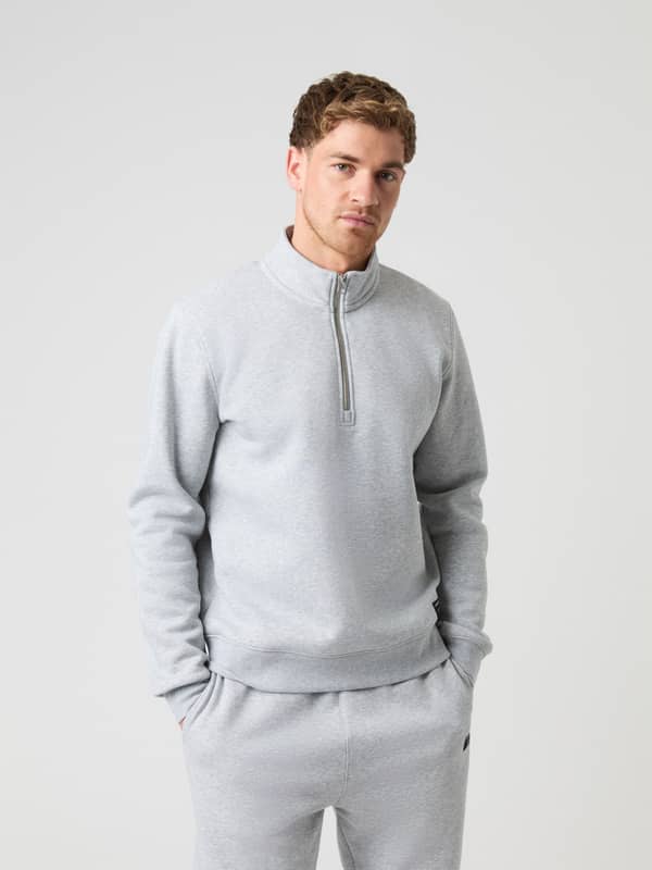 Front view of a model wearing the light grey melange Björn Borg Centre Half Zip sweater.