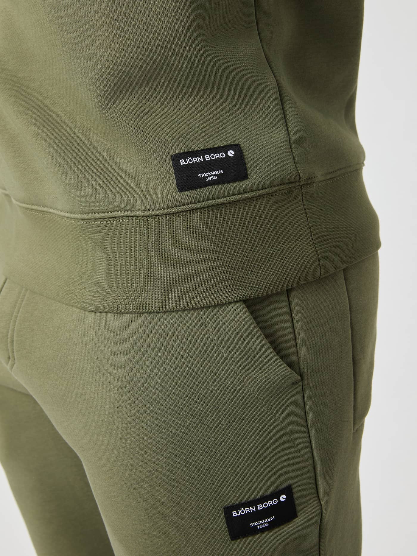 Close-up of the Björn Borg Centre Half Zip sweater in Dusty Olive, showing the ribbed hem and logo label. - Image 5