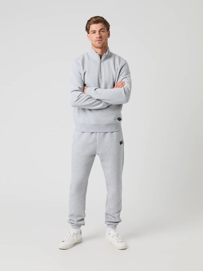 Man in de Björn Borg Centre Half Zip in Light Grey Melange (Grijs) met bijpassende track pants, armen over elkaar. - Image 3