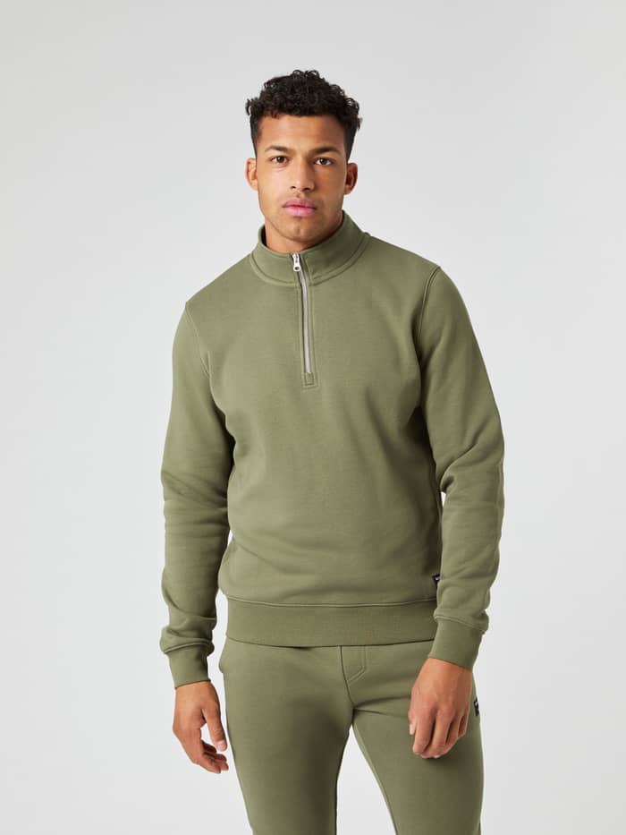 Male model wearing the Björn Borg Centre Half Zip in Dusty Olive, seen from the front.