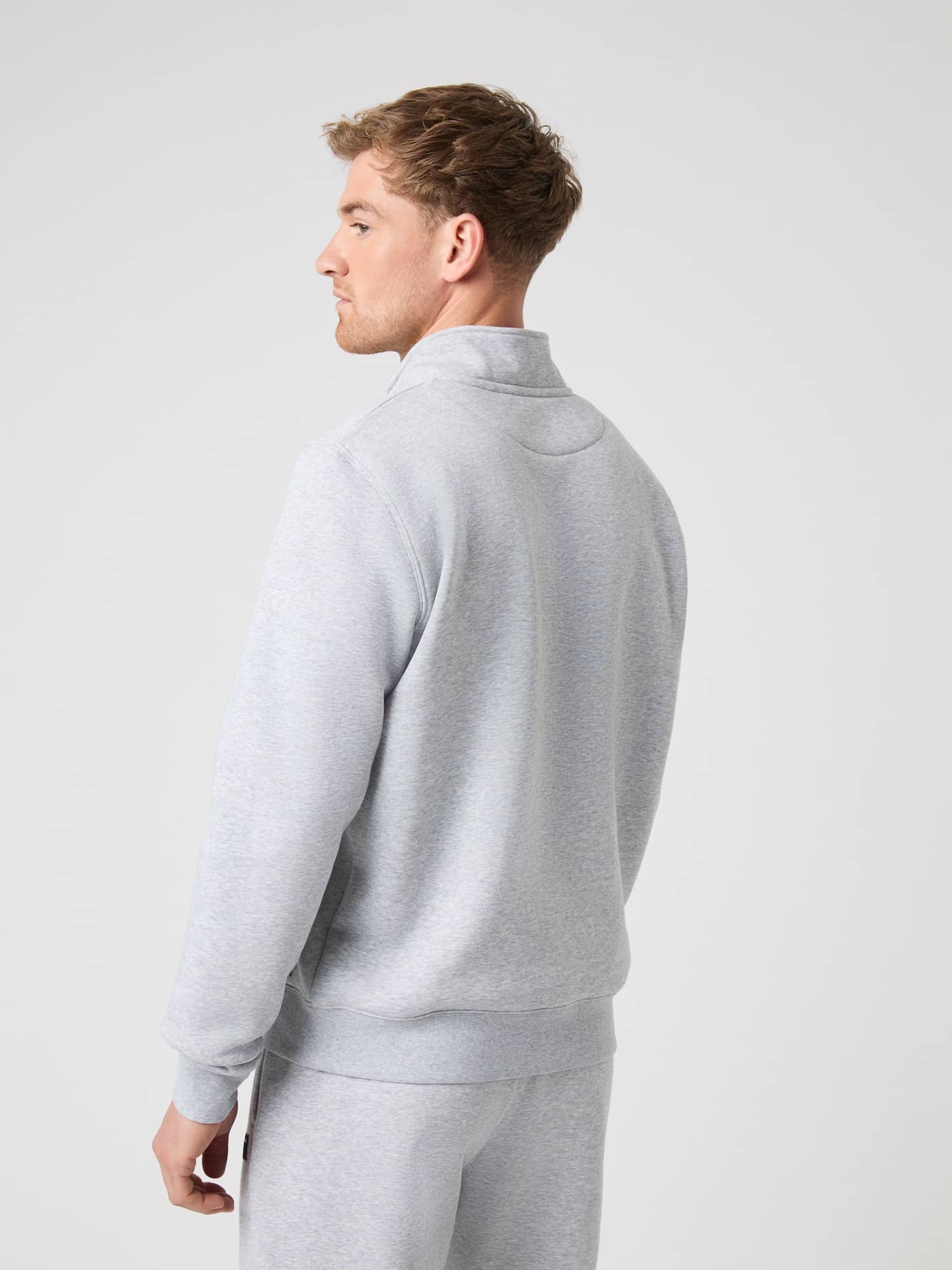 Side and back view of a male model wearing the light grey melange Björn Borg Centre Half Zip sweater. - Image 2