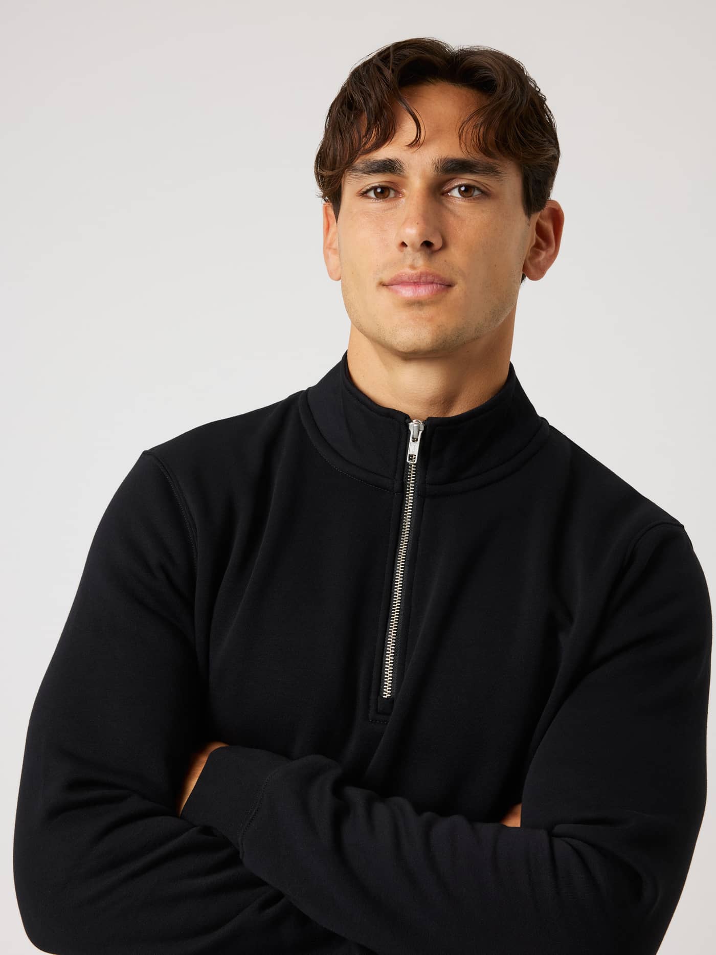 Front portrait of a model in the Centre Half Zip in Black Beauty (Black), showing the mock neck and metal zipper. - Image 5