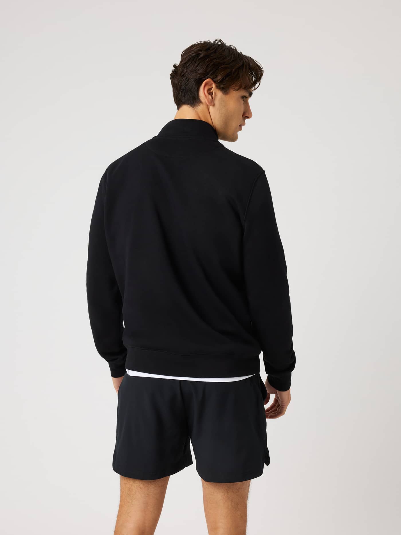 Back view of a model wearing the Centre Half Zip in Black Beauty (Black) with a soft fleece finish. - Image 2