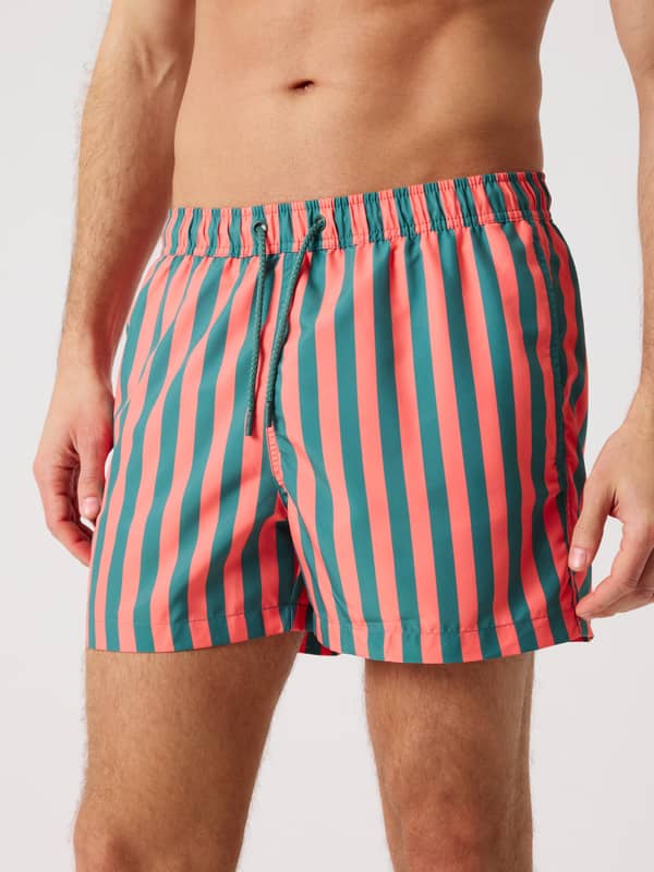 Borg Print Swim Shorts à rayures Parasol 4 (vert et rouge) portés par un homme, en polyester recyclé à séchage rapide.