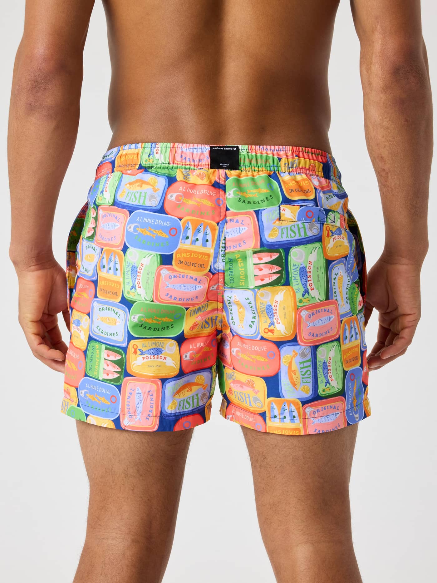 Vista posterior de los Borg Print Swim Shorts en Sardines 1 en azul, verde, rojo y amarillo con parche de logotipo negro. - Image 2