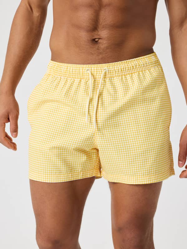 Front view of a man wearing the Björn Borg Print Swim Shorts in Houndstooth 2 (Yellow) featuring a stylish houndstooth print.