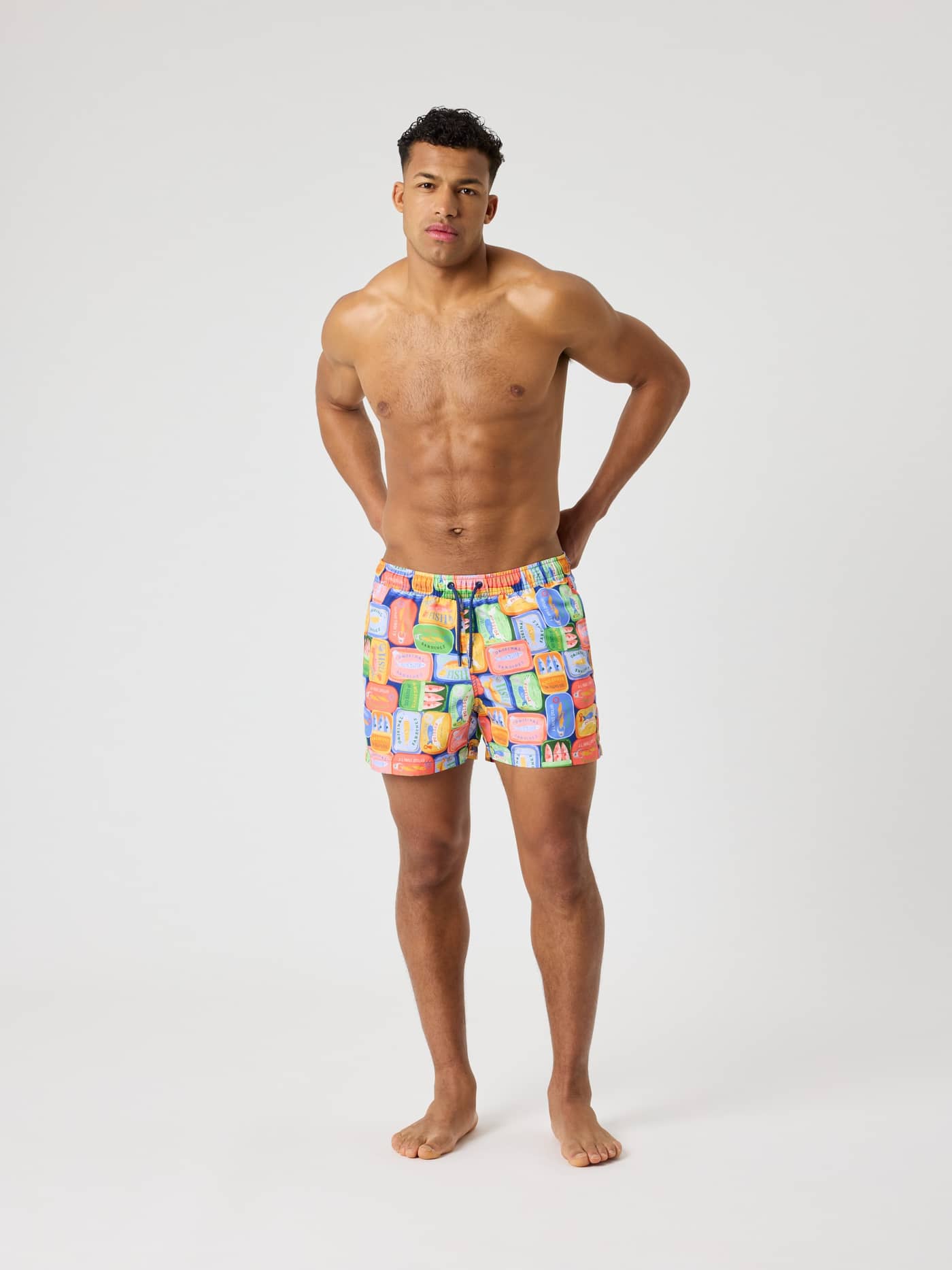 Vista frontal de hombre con Borg Print Swim Shorts de secado rápido y estampado de sardinas en azul, verde, rojo y amarillo. - Image 3