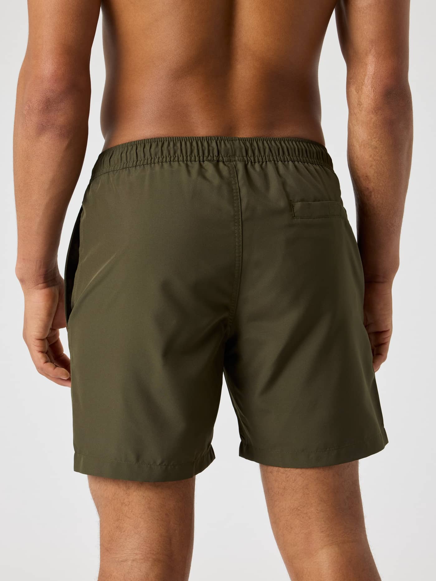 Back view of a man wearing the Borg Swim Shorts in Forest Night (Green), showcasing the regular fit and back pocket. - Image 2