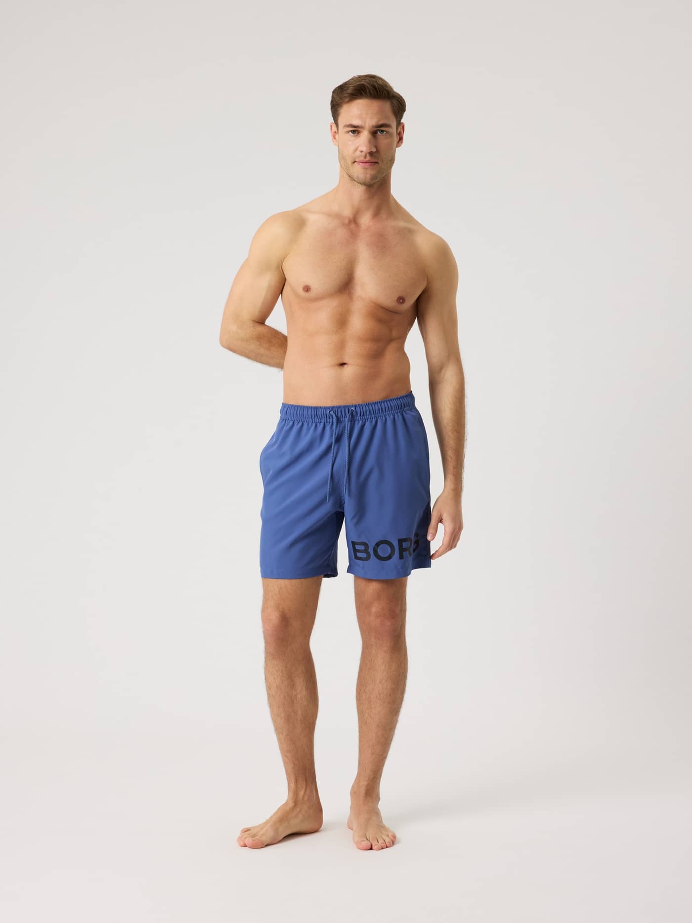 Vista frontal de hombre con Borg Swim Shorts en Coastal Fjord (Azul) con logotipo y cordón ajustable. - Image 3