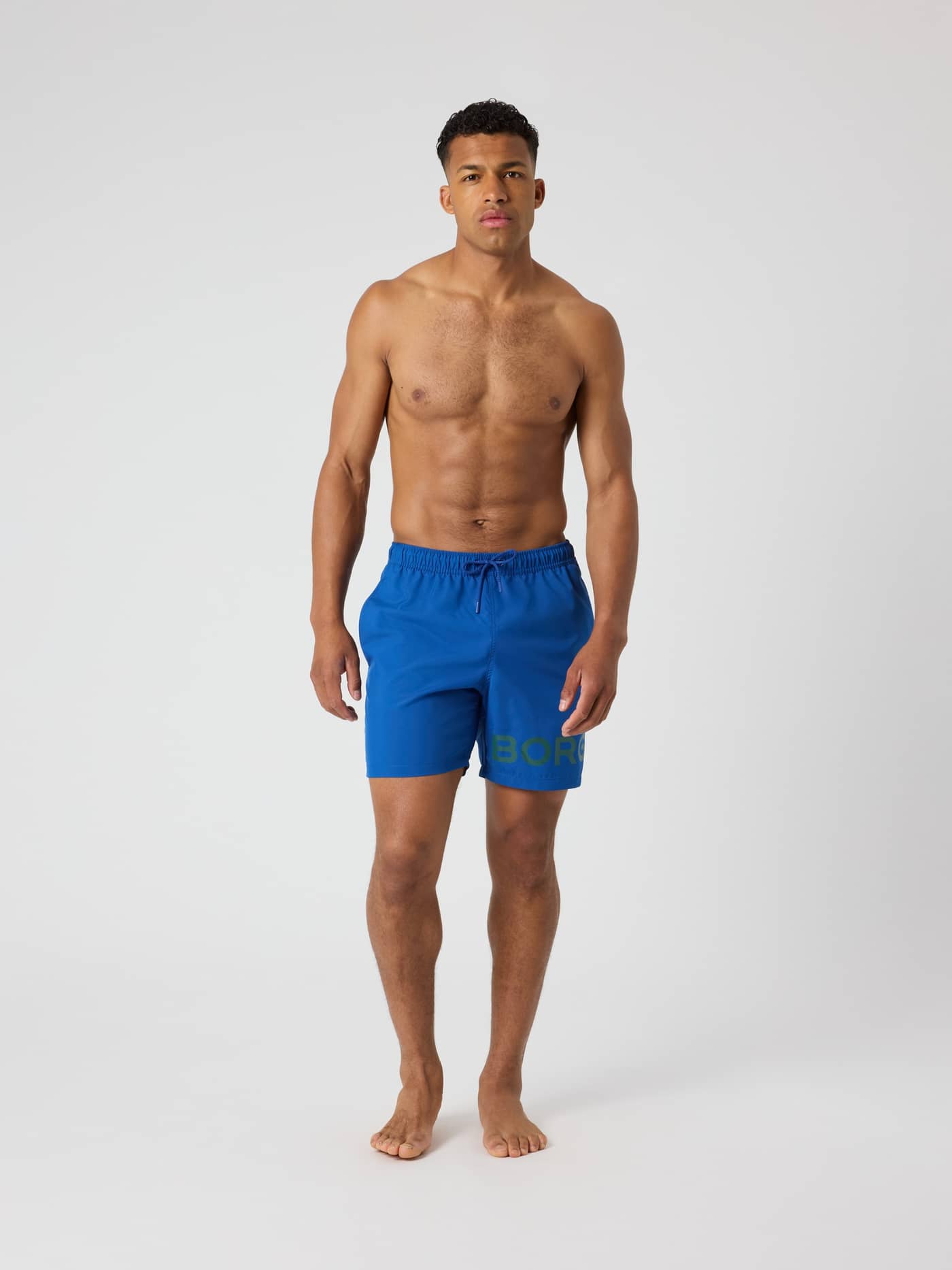 Sneldrogende Borg Swim Shorts in Monaco Blue (Blauw) met een groen logo, getoond op een man in een vooraanzicht. - Image 3