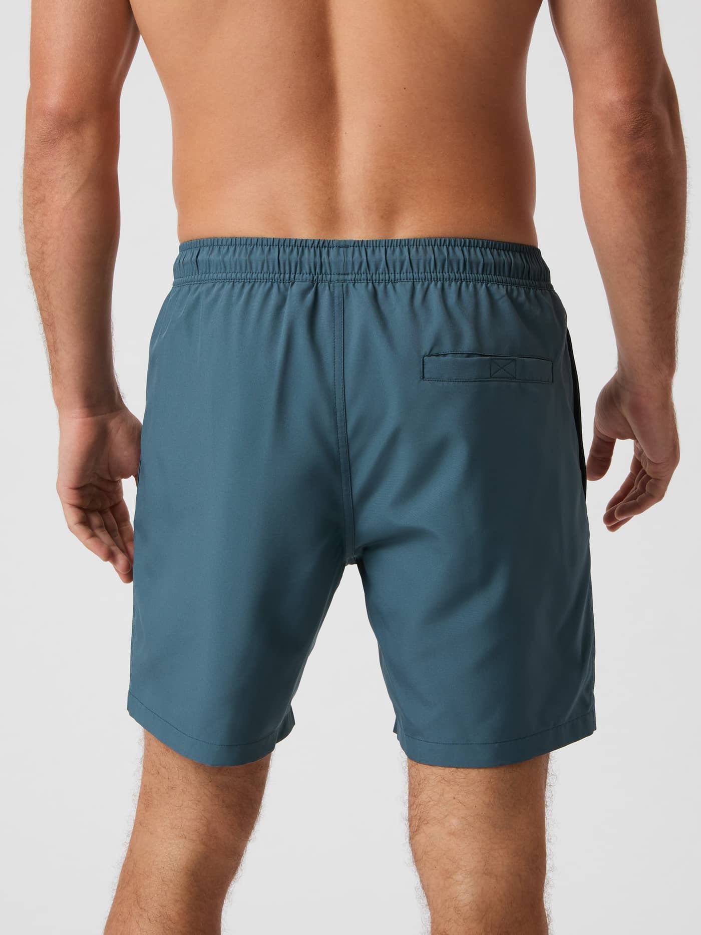 Back view of a man wearing the Borg Swim Shorts in Orion Blue (Blue), featuring a functional back pocket and regular fit. - Image 3