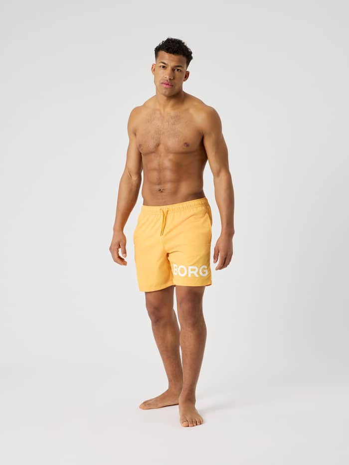 Sneldrogende Borg Swim Shorts in Marigold (Geel) met een wit logo, getoond in een vooraanzicht van een man. - Image 3