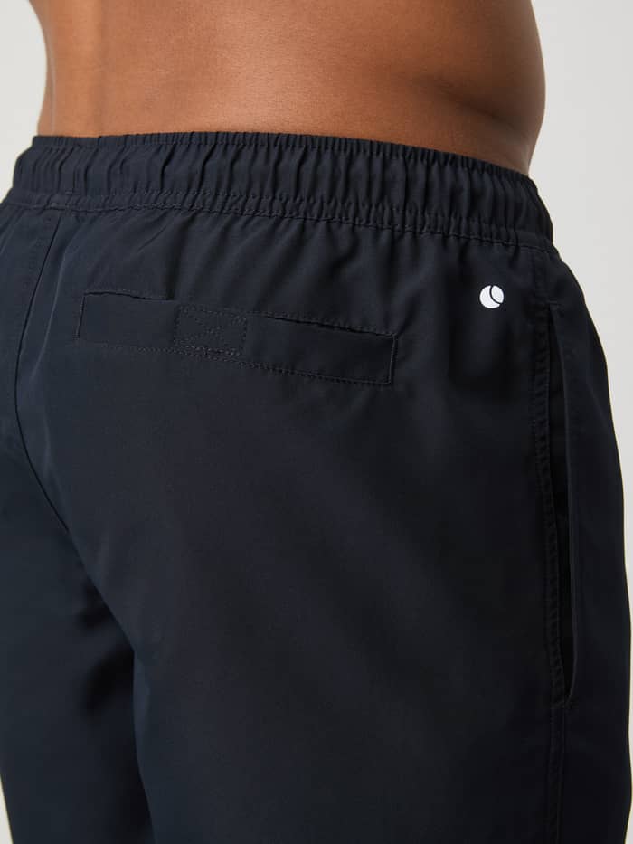 Achteraanzicht van de sneldrogende Borg Swim Shorts in Night Sky (Marineblauw) met achterzak met klittenband en wit logo. - Image 4