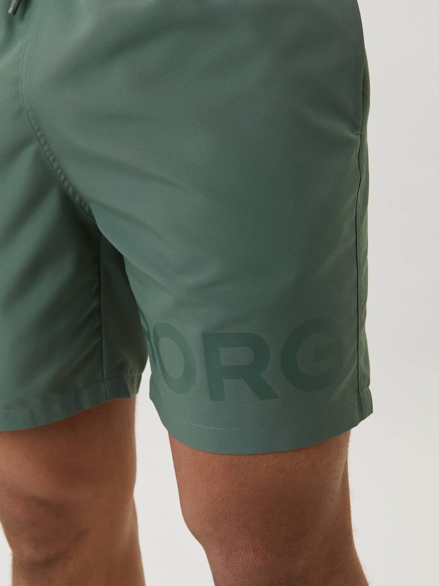 Close-up of the Borg Swim Shorts in Duck Green (Green) featuring a large tonal green logo on the leg. - Image 4