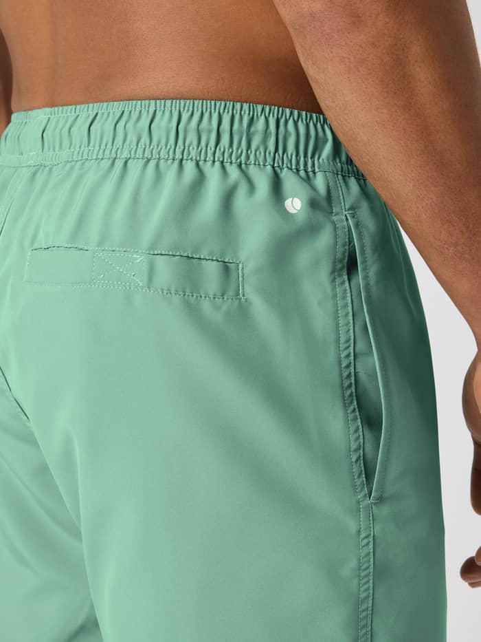 Borg Swim Shorts in Malachite Green (Groen) van sneldrogend materiaal met een tennisbal-detail in close-up. - Image 4