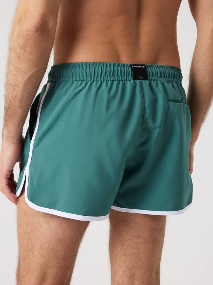 Achteraanzicht van de Borg Retro Swim Shorts in Blue Spruce (Groen) met een zwart logo op de tailleband. - Image 2