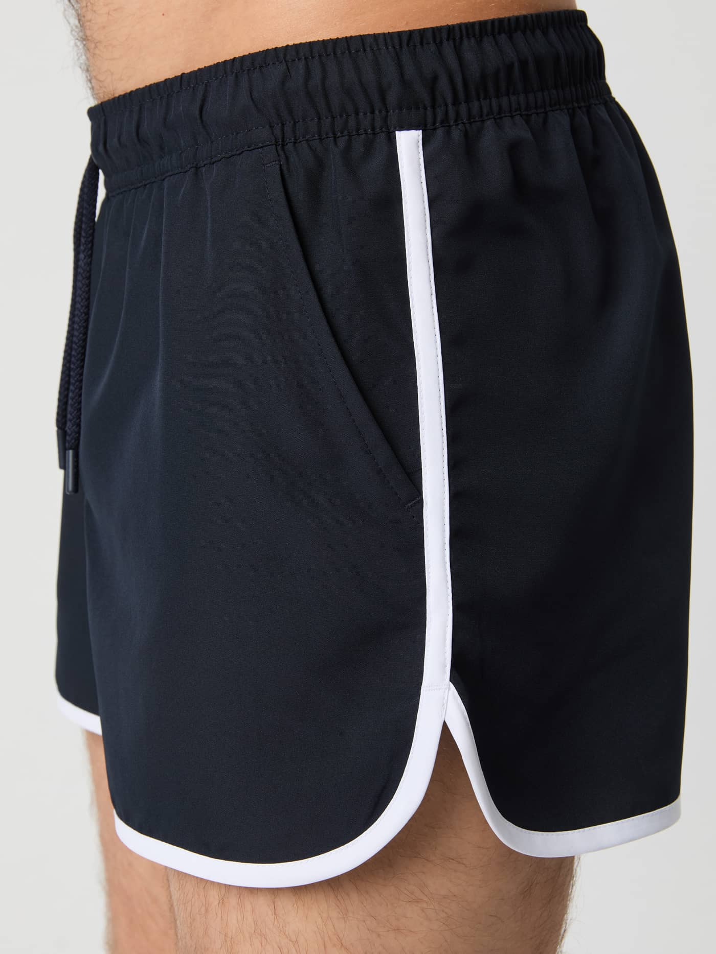 Vue de côté du Borg Retro Swim Shorts en Night sky (Bleu marine) avec liséré blanc et matière à séchage rapide. - Image 4