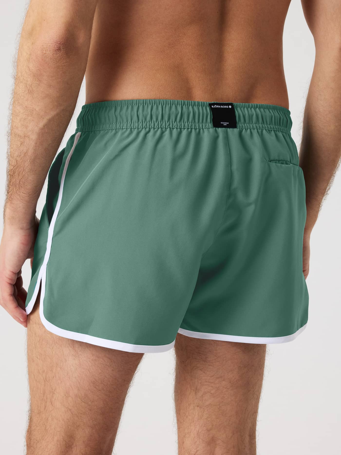 Borg Retro Swim Shorts i Duck Green (Grön) sedda bakifrån med vita kantband och en svart logoetikett för stil och funktion. - Image 2