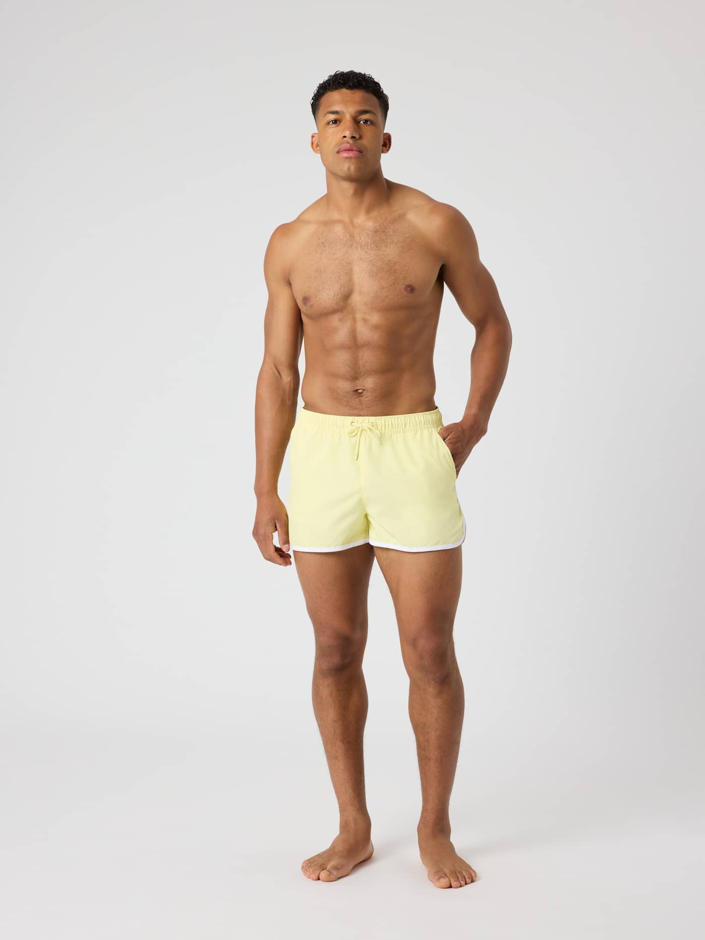 Full-body front view of a man wearing the Björn Borg Retro Swim Shorts in Lemonade (Yellow). - Image 3