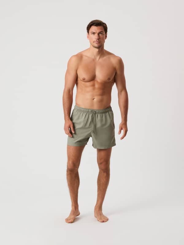 Borg Solid Swim Shorts i Vetiver (Grøn) med løs pasform og snøre i taljen, vist forfra i fuld figur på en mand.