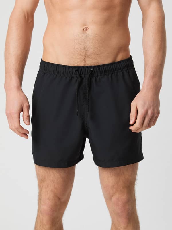 Borg Solid Swim Shorts i Black Beauty (Sort) med løs pasform og snøre i taljen set forfra på en mand.
