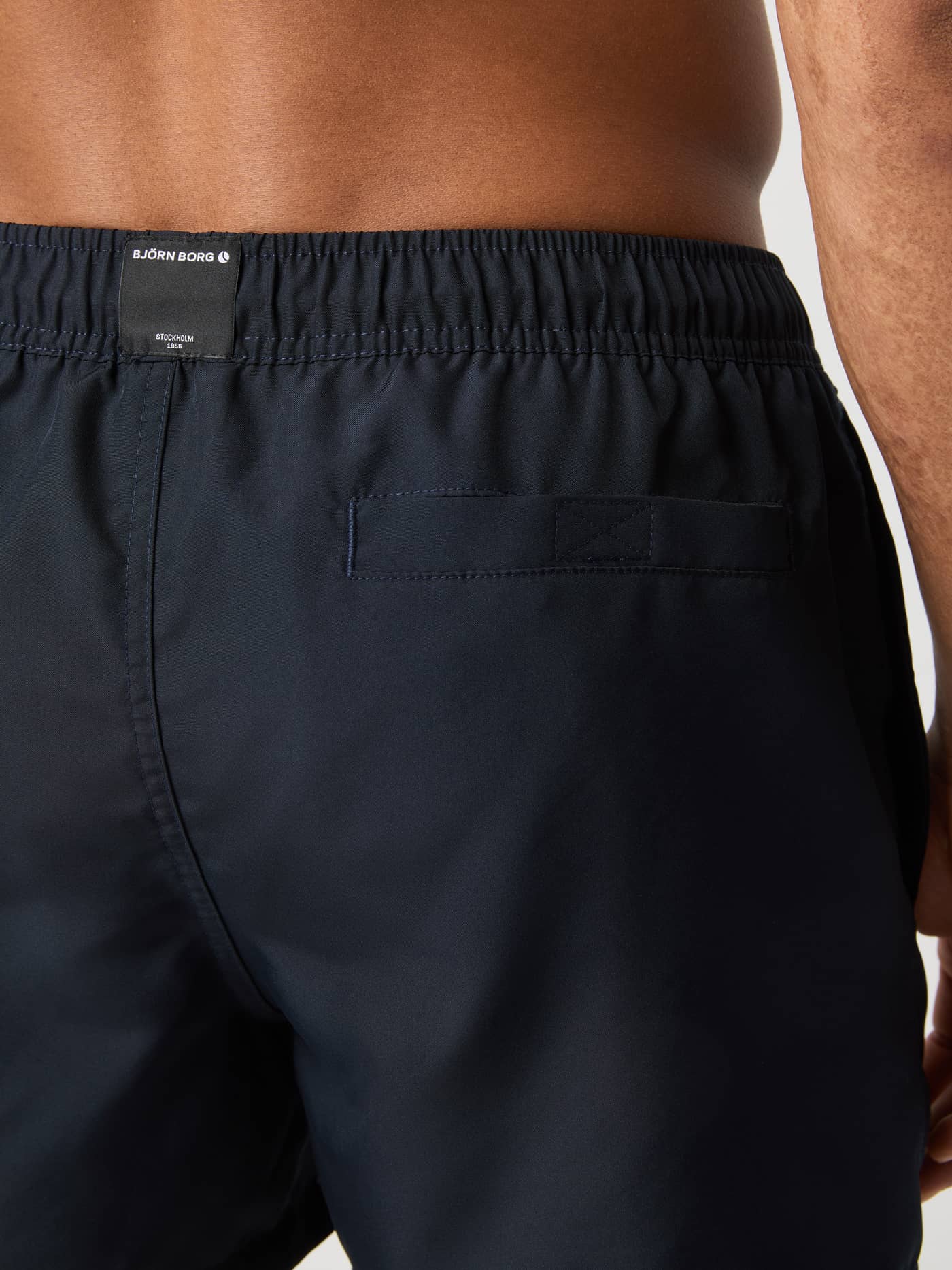 Vue arrière du Borg Solid Swim Shorts en Night sky (Bleu marine) avec poche Velcro et logo blanc. - Image 4