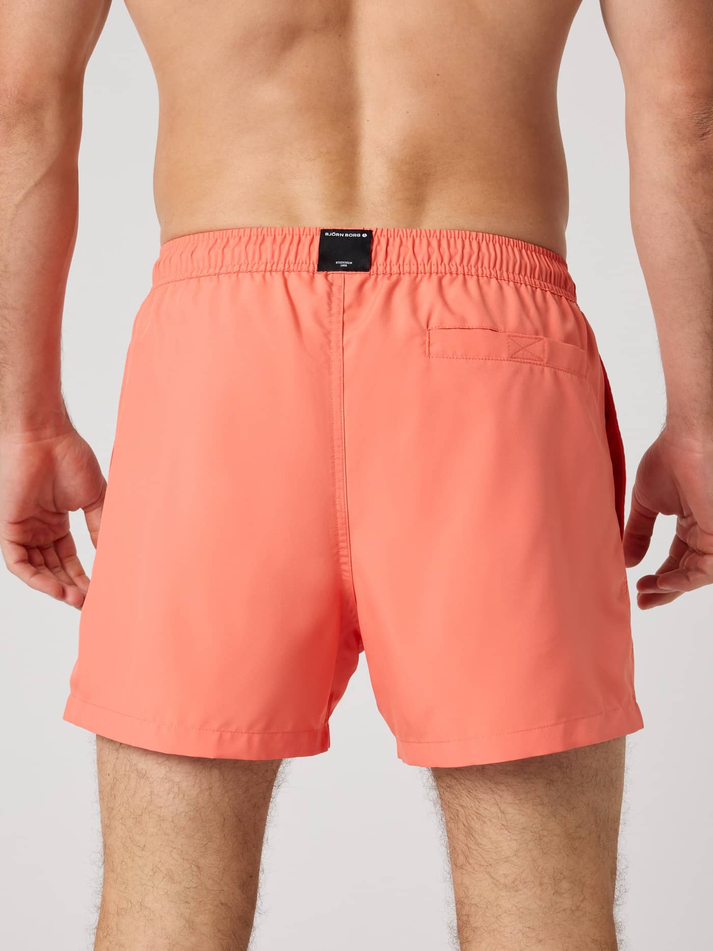 Borg Solid Swim Shorts in Coral (Orange) mit schwarzem Logo-Label und Klettverschlusstasche in der Rückansicht. - Image 2