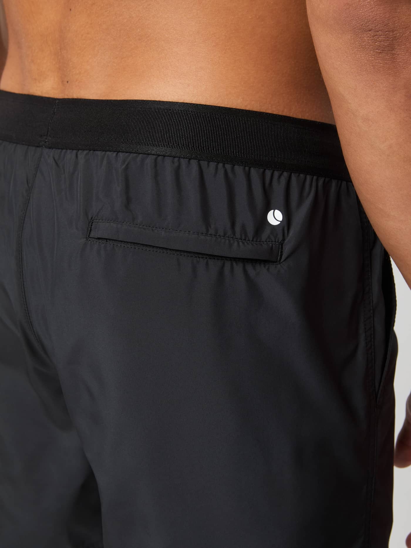 Detailed back view of the Borg Premium Swim Shorts in Black Beauty (Black), showing the Velcro pocket and white logo. - Image 4