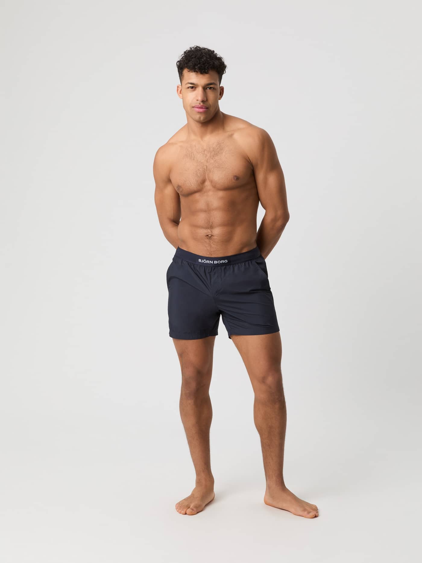 Full-body front view of a man wearing the regular-fit Borg Premium Swim Shorts in Night Sky (Navy). - Image 1