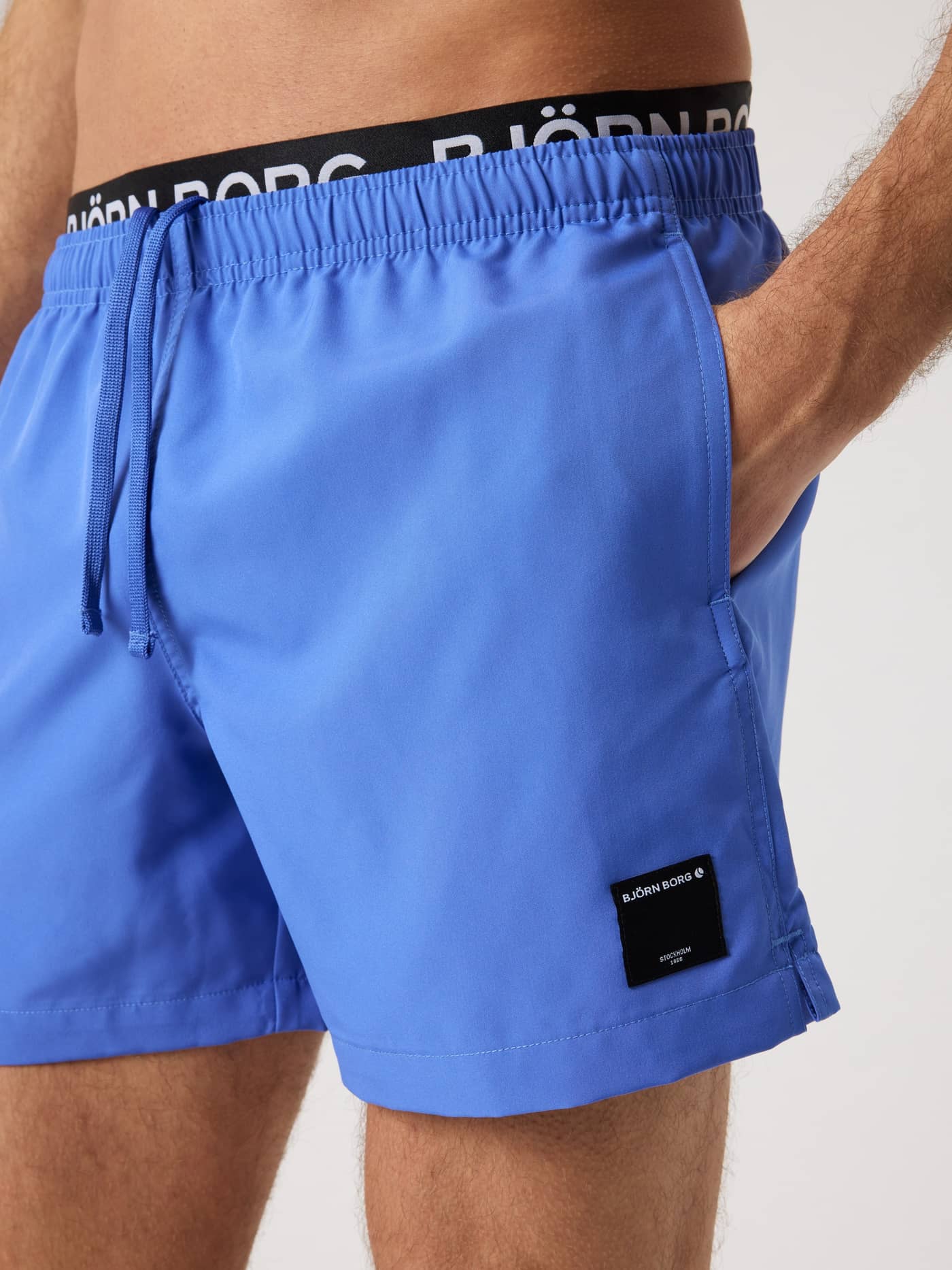Close-up of the Borg Elastic Swim Shorts in Amparo Blue (Blue) featuring a branded logo waistband and drawstring. - Image 4