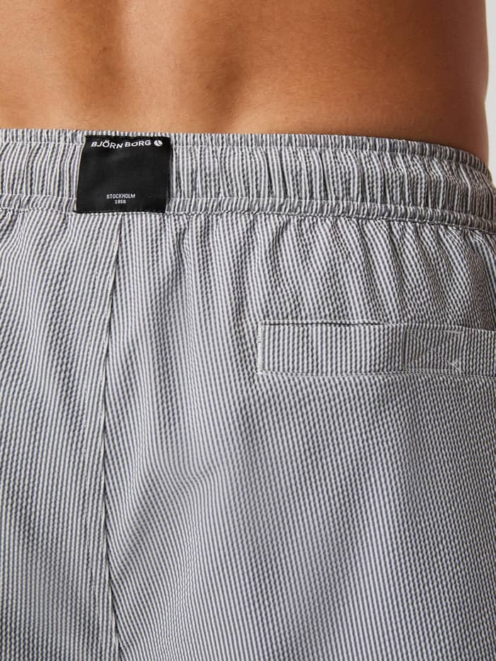 Achterdetail van de Borg Seersucker Swim Shorts in Swim Stripe 4 (Grijs) met een klittenbandzak en zwart logo-label. - Image 4