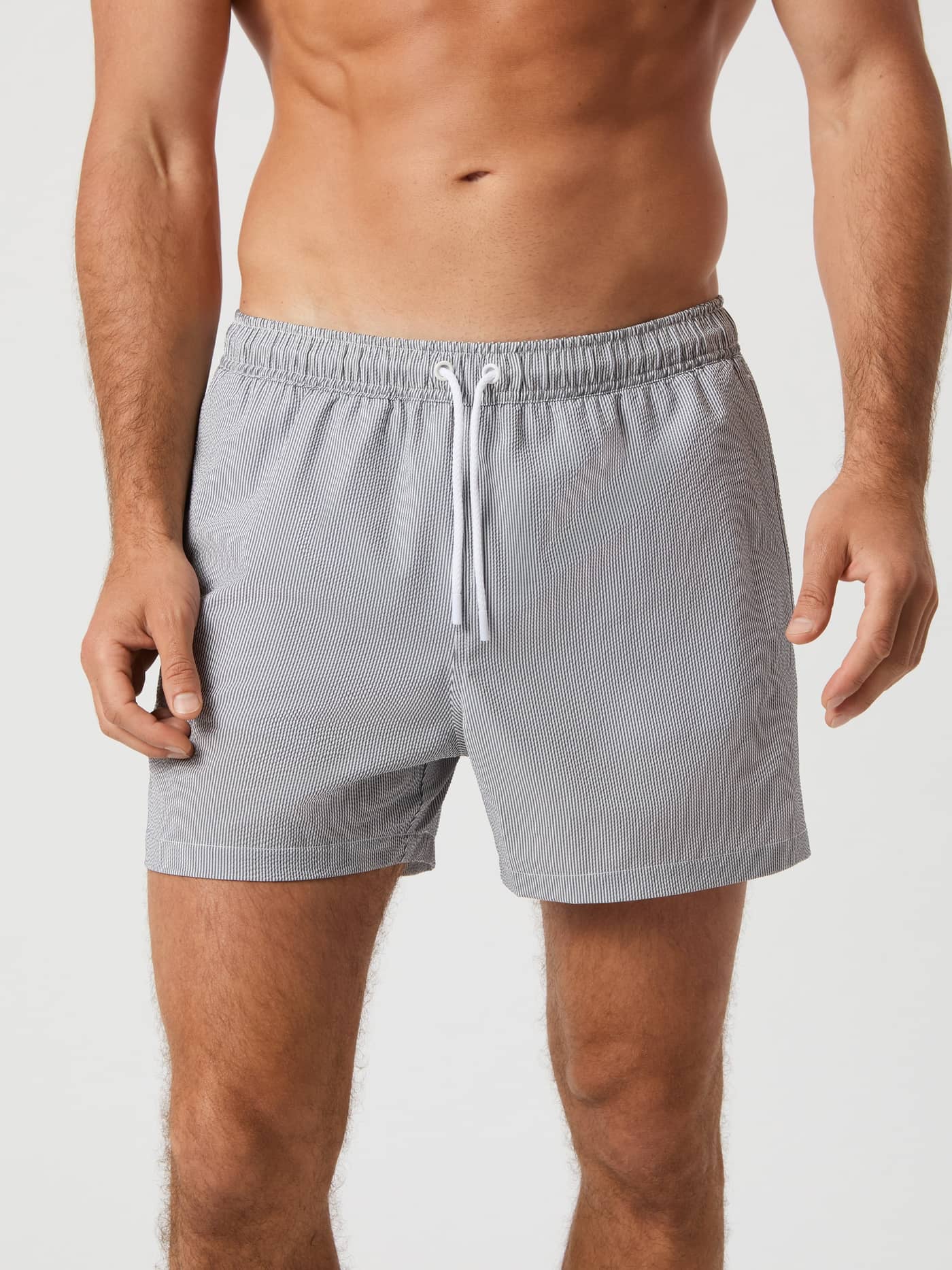 Front view of a man wearing the Borg Seersucker Swim Shorts in Swim Stripe 4 (Grey) featuring a stylish seersucker fabric. - Image 2