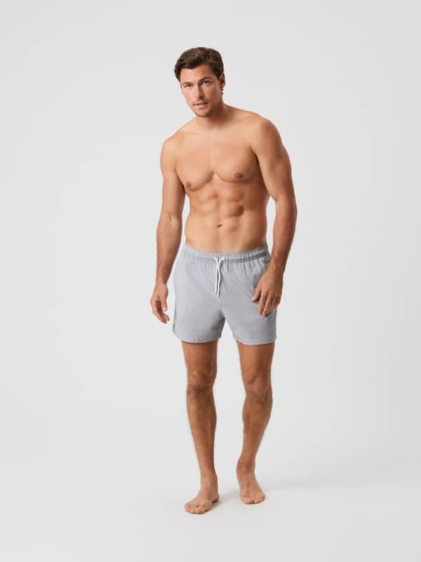 Borg Seersucker Swim Shorts i Swim Stripe 4 (Grå) med stribet mønster og løs pasform, vist forfra på en mand.