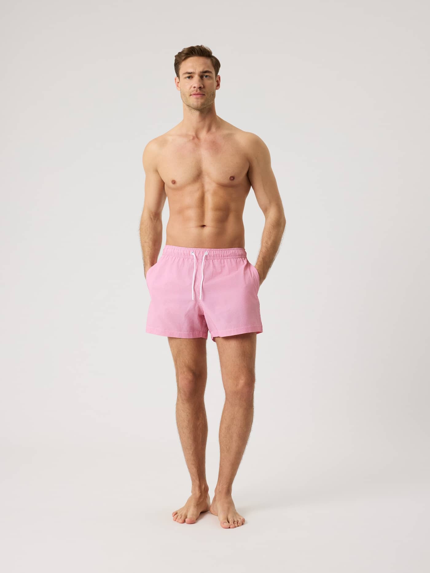Vista frontal de hombre con Borg Seersucker Swim Shorts en Searstripe 3 (Rojo) de corte holgado y textura de rayas. - Image 3