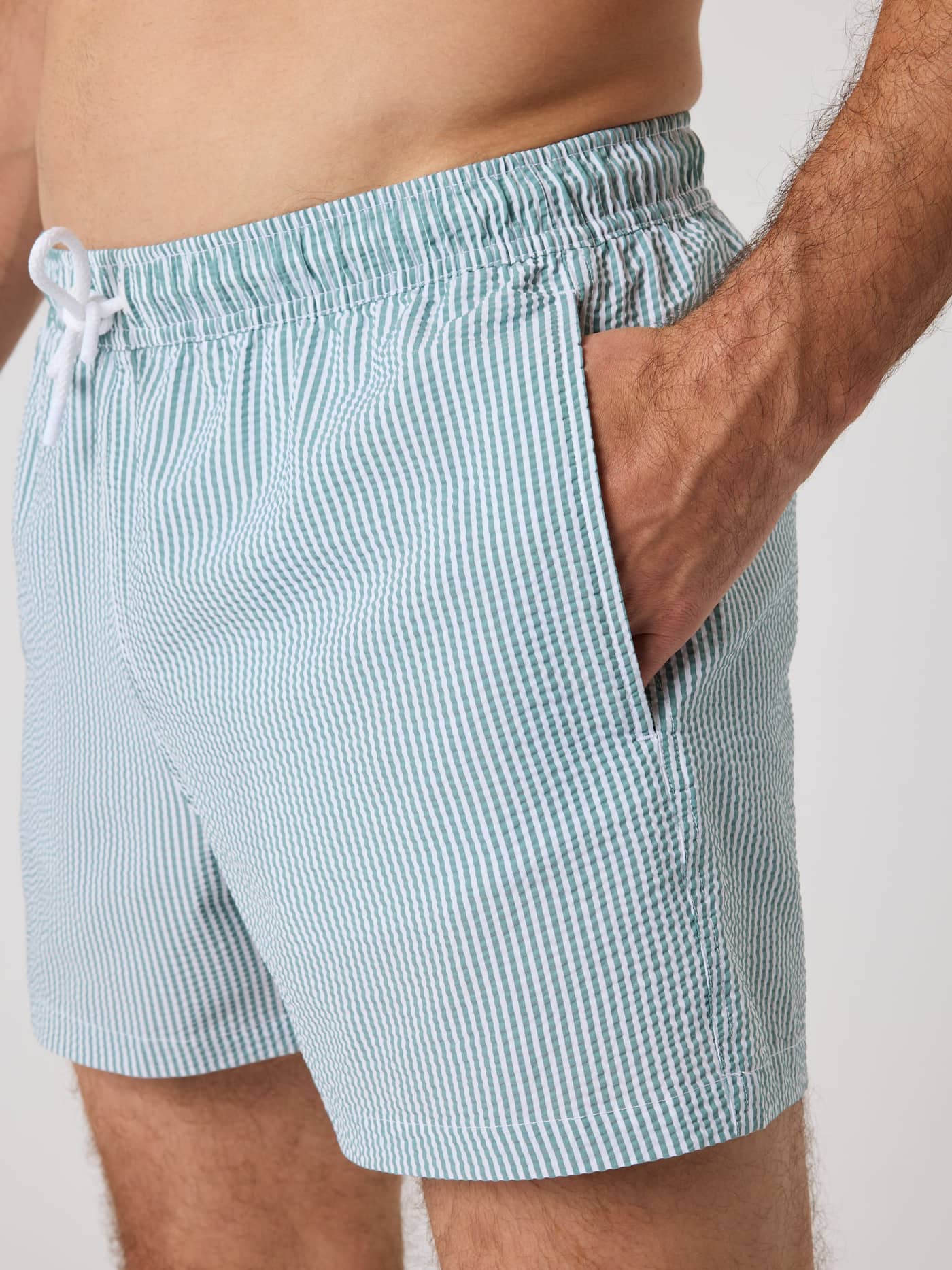 Borg Seersucker Swim Shorts in Searstripe 5 (Blue), side view showing loose fit, striped seersucker fabric and side pockets. - Image 5