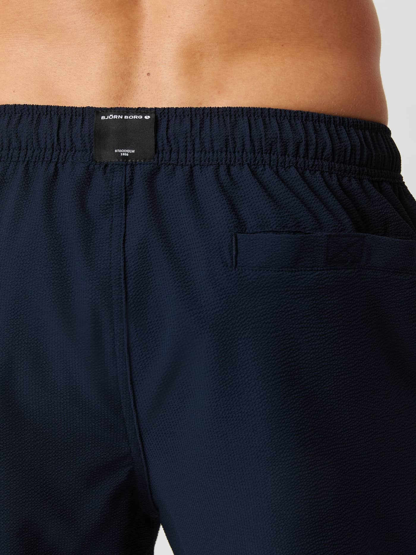 Primer plano posterior de los Borg Seersucker Swim Shorts en Night sky (Azul marino) con tejido seersucker y logo blanco. - Image 4