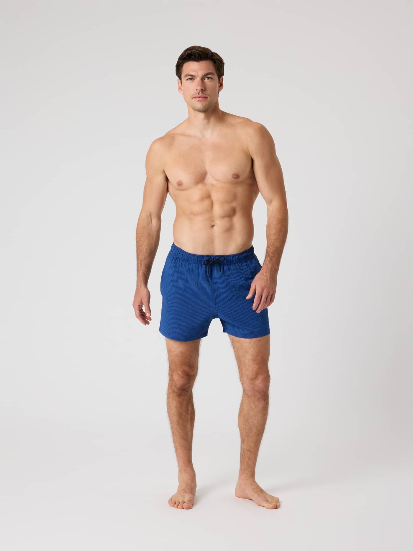 Vista frontal de cuerpo completo de hombre con Borg Seersucker Swim Shorts en Searstripe 4 (Azul) a rayas y corte holgado. - Image 3