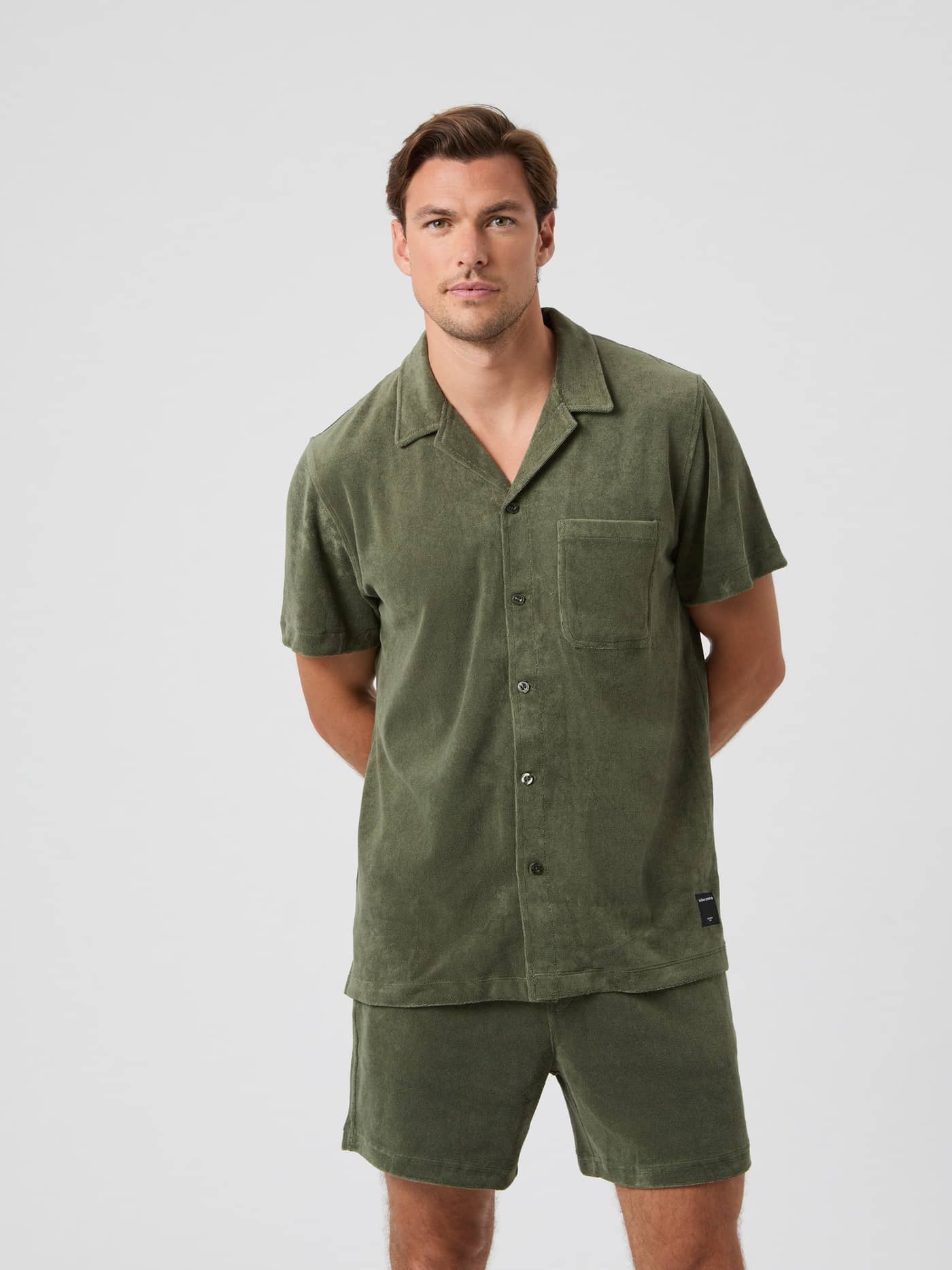 Vorderansicht eines Mannes im Borg Toweling Pool Shirt in Beetle (Grün) aus weichem Frottee mit normaler Passform. - Image 3