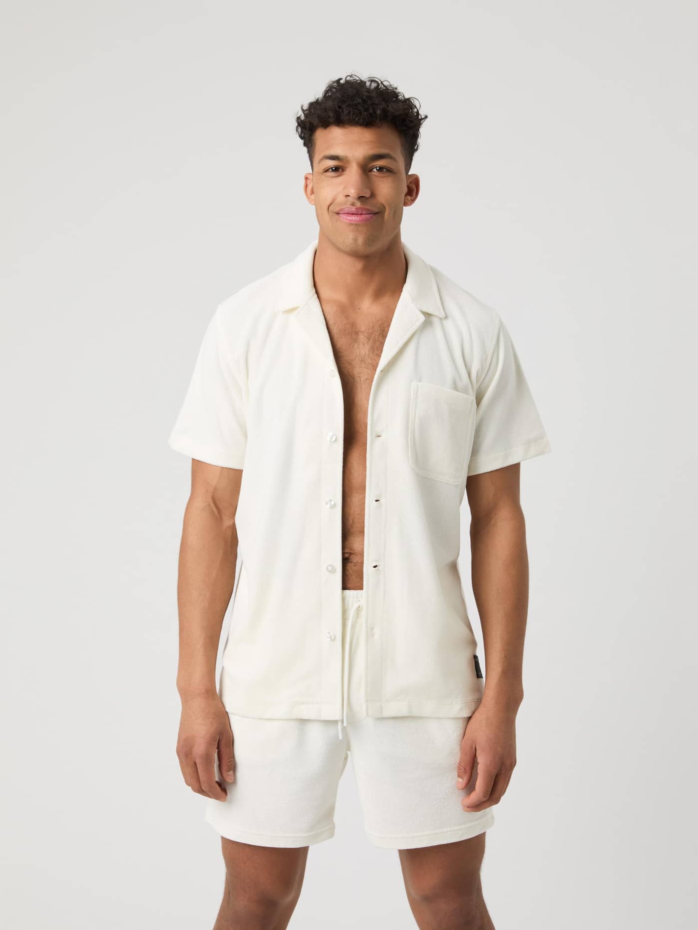 Front view of a man in the Borg Toweling Pool Shirt in Egret (White), with a black logo label and stylish, functional fit. - Image 1