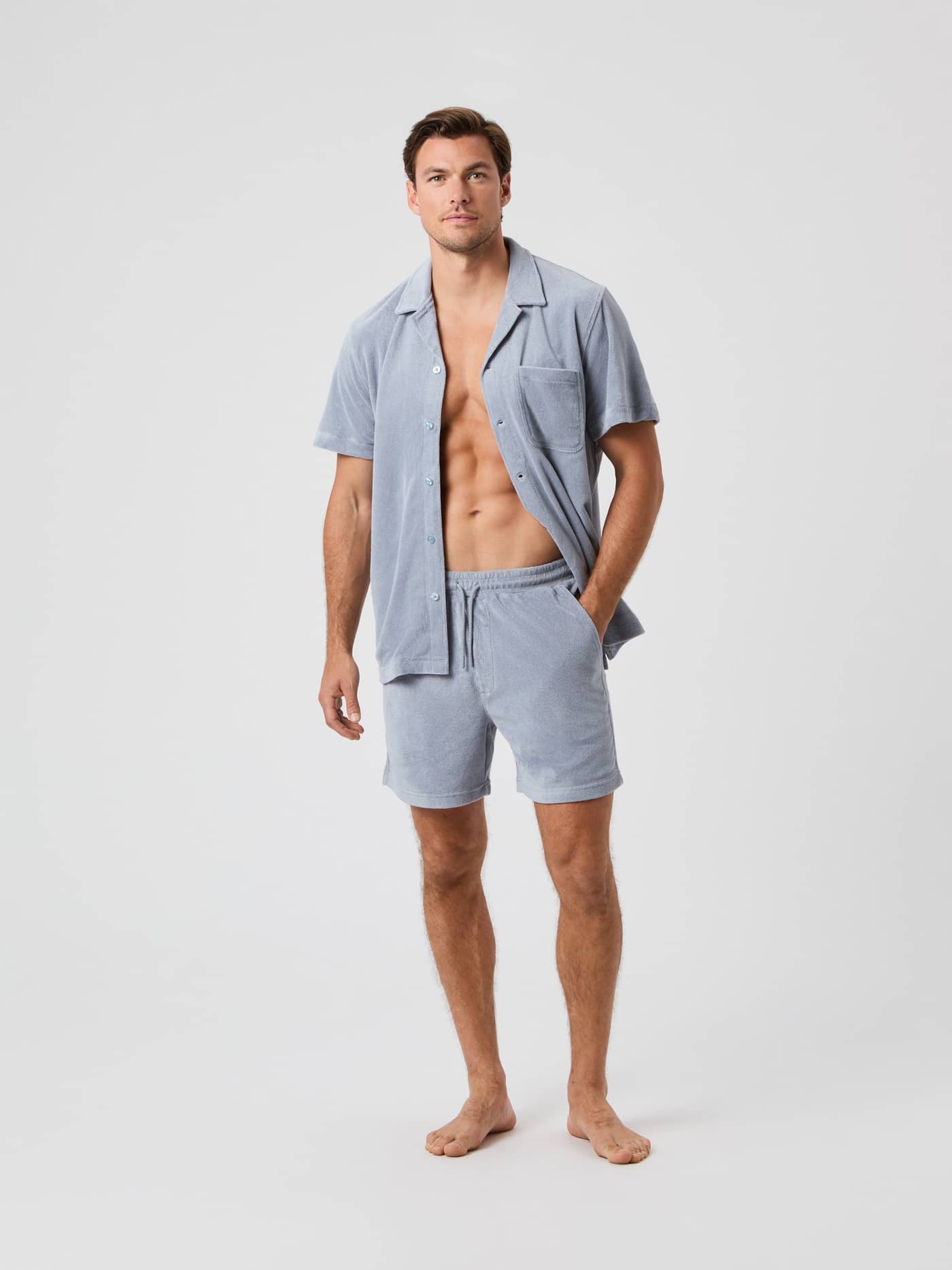 Full-body front view of a man wearing the Borg Toweling Pool Shirt in Tradewinds (Grey) and matching shorts. - Image 3