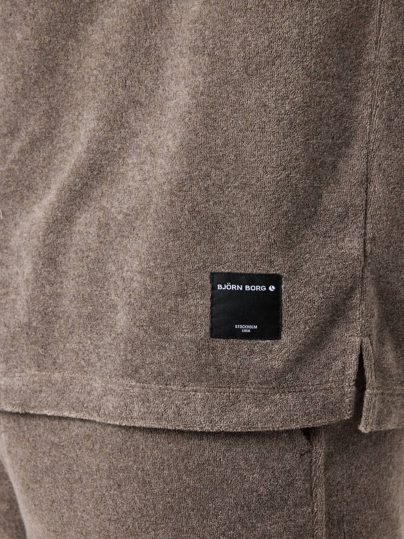 Borg Toweling Pool Shirt i Taupe Melange (Beige) set i nærbillede med sort logo-label og sideslids i frotté. - Image 4