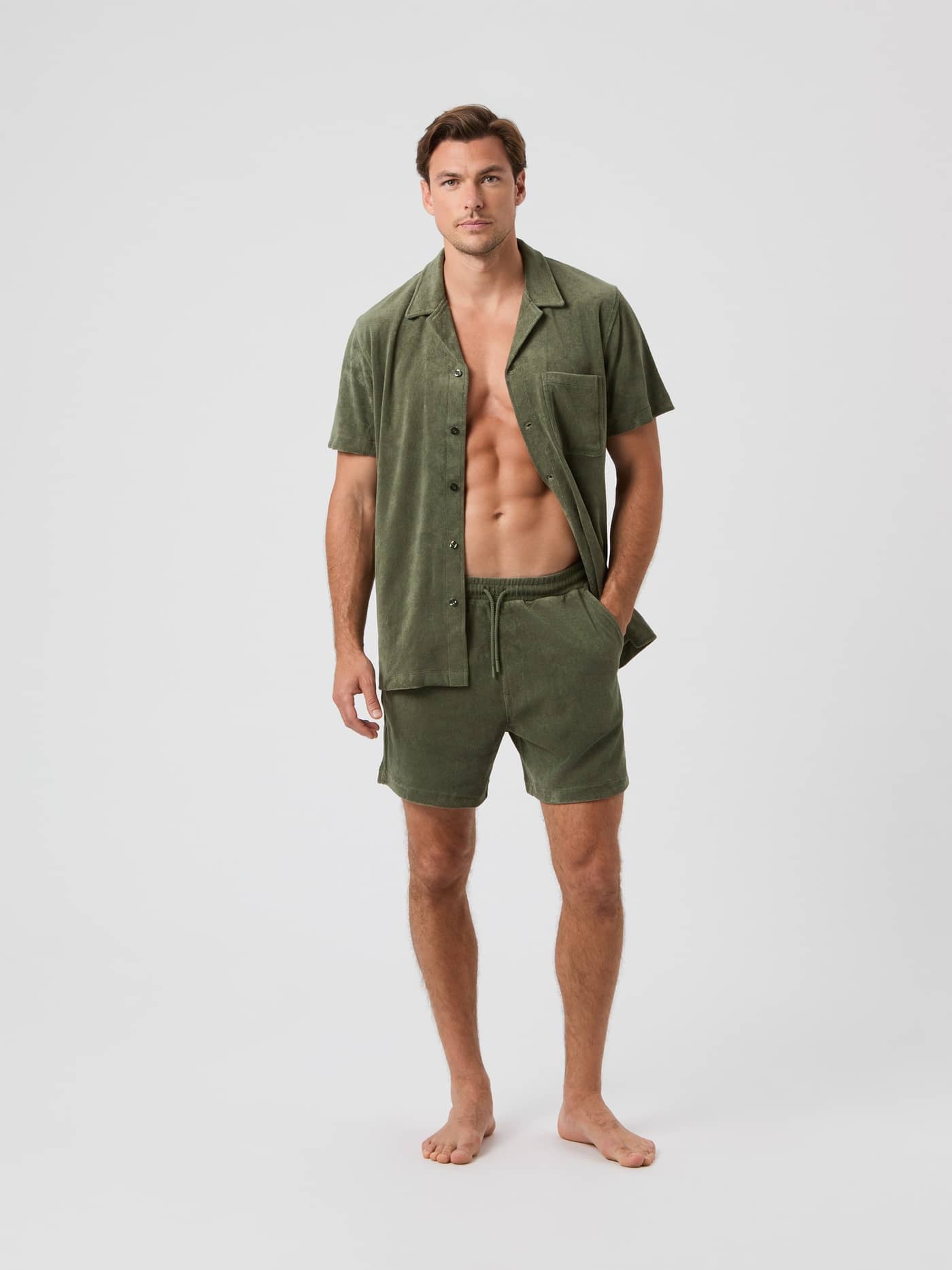 Ganzkörper-Vorderansicht eines Mannes im Borg Toweling Pool Shirt aus Frottee in Beetle (Grün) mit Brusttasche. - Image 2