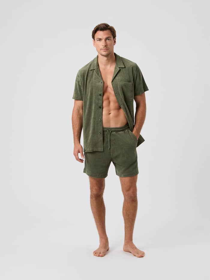 Ganzkörper-Vorderansicht eines Mannes im Borg Toweling Pool Shirt aus Frottee in Beetle (Grün) mit Brusttasche. - Image 2