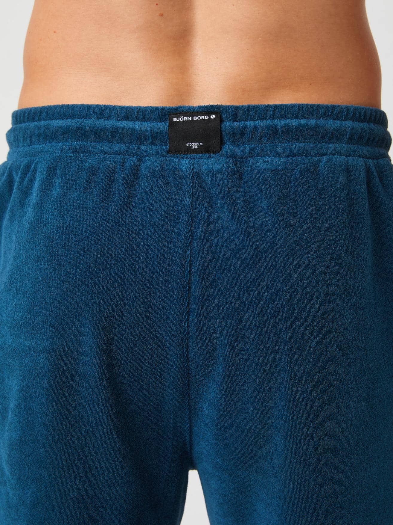 Close-up back view of the Borg Toweling Pool Shorts in Gibraltar Sea (Blue) showing the woven logo label and toweling fabric. - Image 4