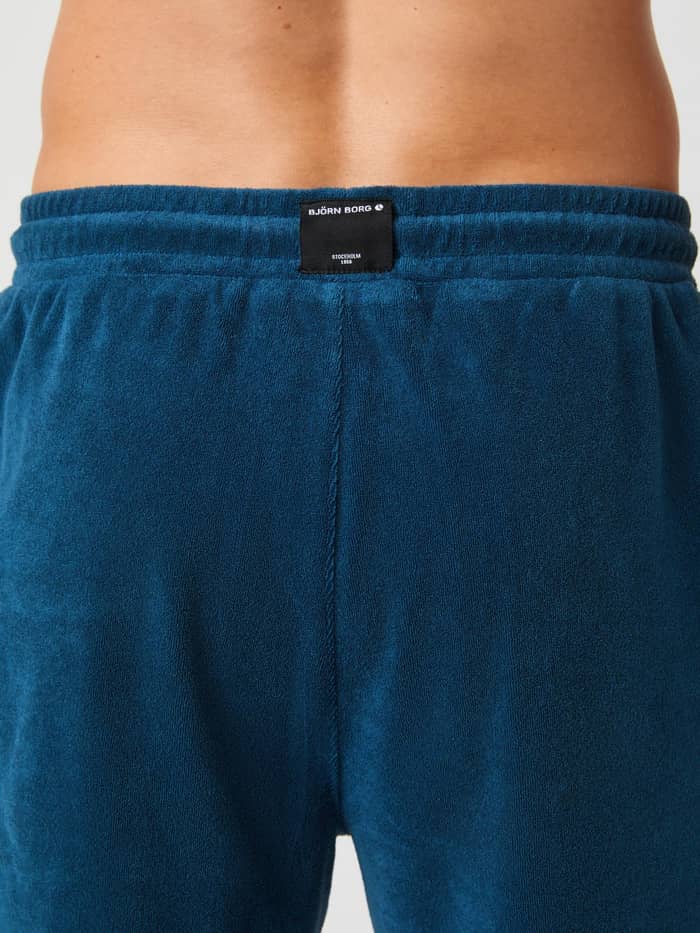 Close-up achteraanzicht van de Borg Toweling Pool Shorts in Gibraltar Sea (Blauw) van badstof met een geweven logolabel. - Image 4