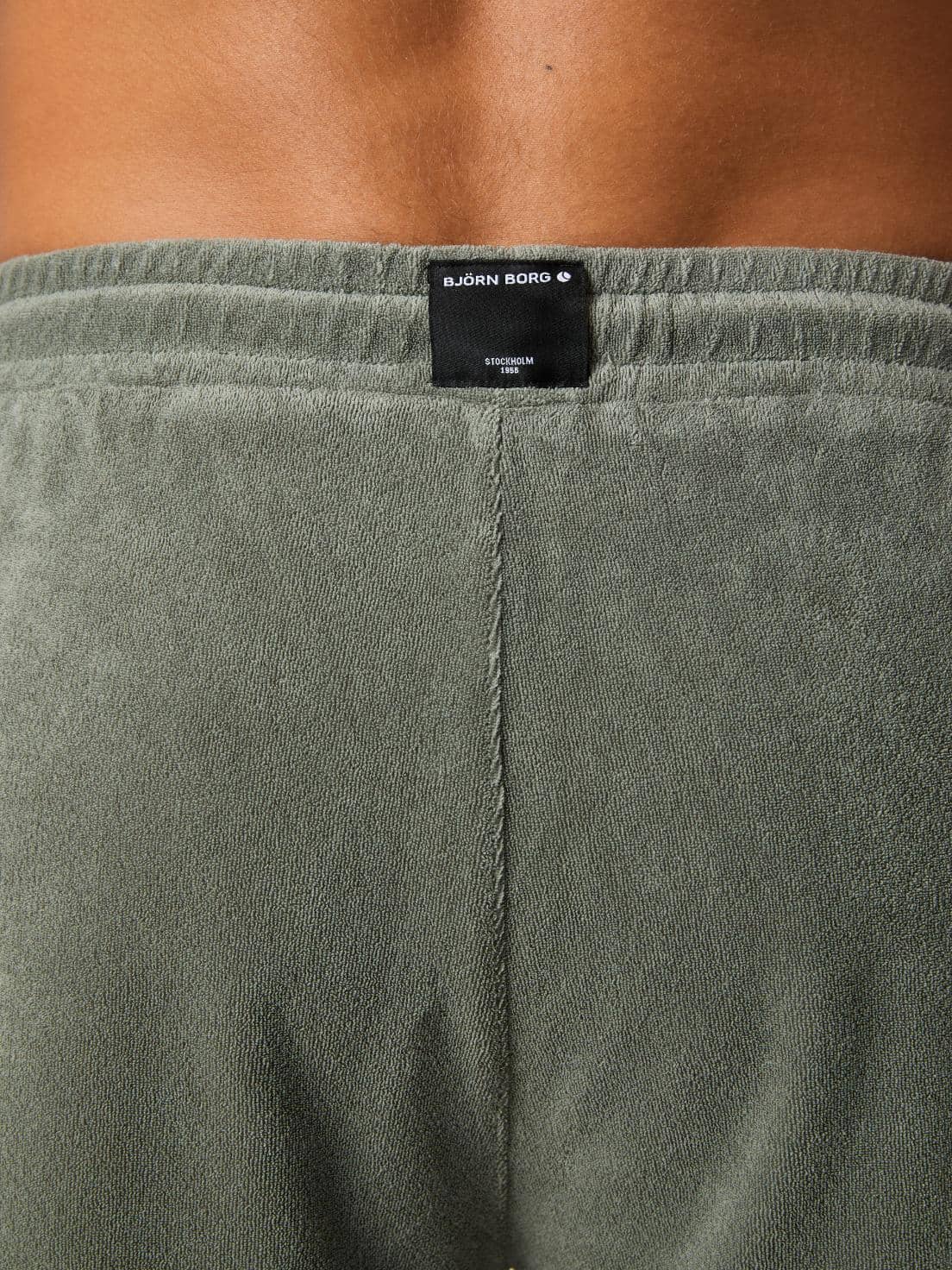 Close-up of the back waistband on the Agave Green (Green) Borg Toweling Pool Shorts, showing the woven logo label. - Image 4