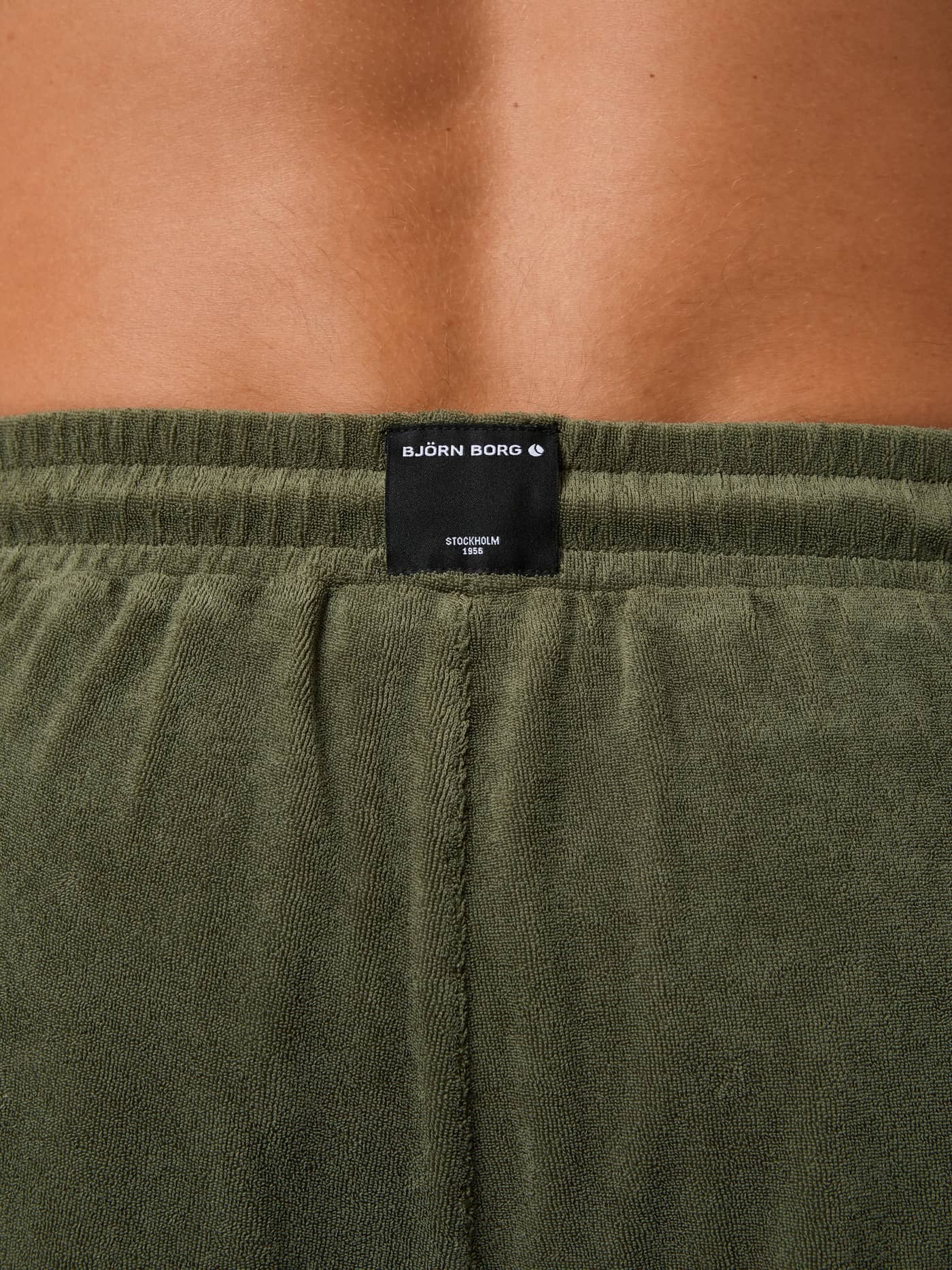 Borg Toweling Pool Shorts i Beetle (Grønn) sett bakfra, med sort vevd logolapp på mykt frottéstoff for menn. - Image 5