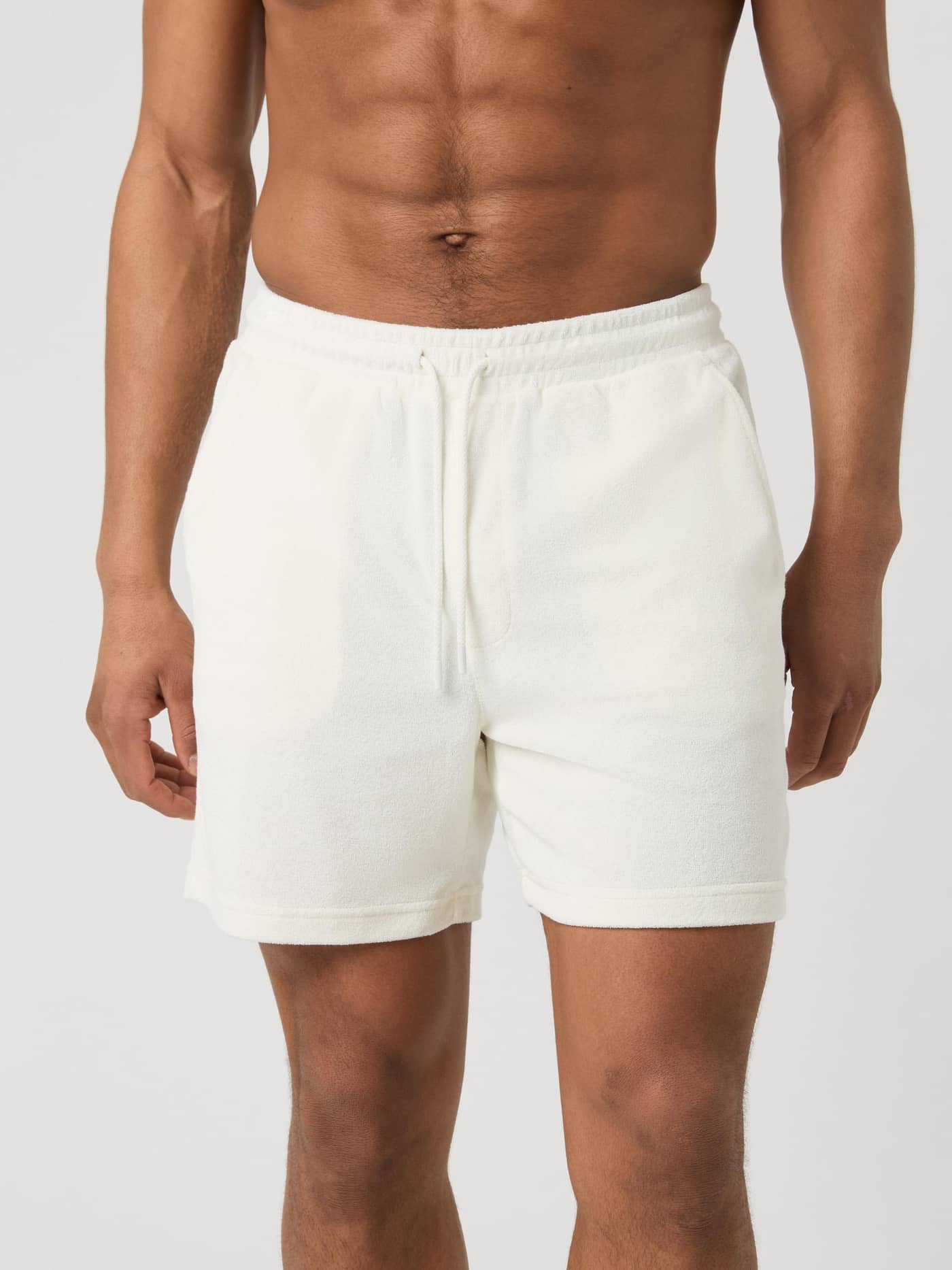 Front view of a man wearing the regular fit Björn Borg Borg Toweling Pool Shorts in Egret (White) toweling fabric. - Image 2