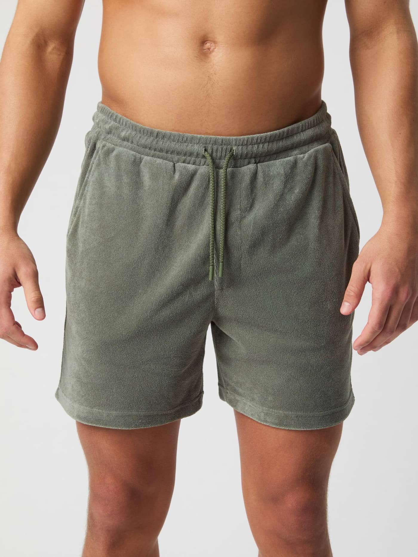 Front view of a man wearing Agave Green (Green) Borg Toweling Pool Shorts in a soft toweling fabric with a drawstring. - Image 2